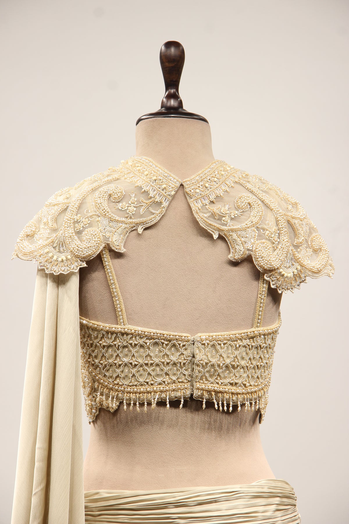 Ivory Satin Drape Skirt Lehenga with Bead & Pearl Handwork Crop Top – back close-up, with cape